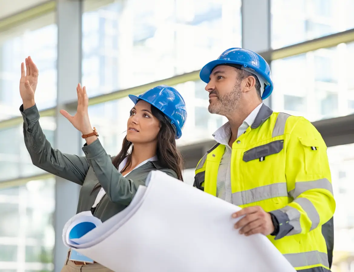 GettyImages-957550680-1 (1) Two construction workers reviewing blueprints.